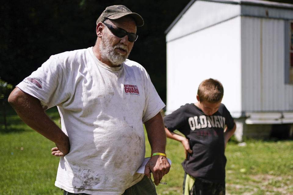 John Ross and his son David talk about their concerns for school reopening in the fall in light of the coronavirus pandemic and the way their limited internet access will hinder home instruction, in Beattyville, Ky., Wednesday, July 29, 2020. “They’re going to have their education,” the father of three said of his determination to get his children back to school after they struggled to do their work this spring over a spotty cellphone connection. (AP Photo/Bryan Woolston)