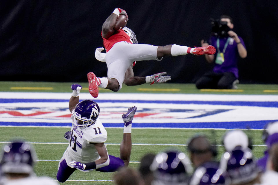 Ohio State running back Trey Sermon, top, is sent flying by Northwestern defensive back A.J. Hampton (11) during the first half of the Big Ten championship NCAA college football game, Saturday, Dec. 19, 2020, in Indianapolis. (AP Photo/AJ Mast)