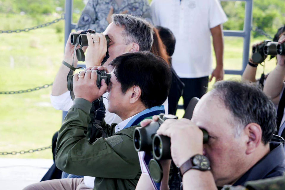 In this photo released by the Philippine Presidential Communications Office, Australian Defence Minister Richard Marles, left, and Philippine President Ferdinand Marcos Jr., center, watch through binoculars a large-scale combined amphibious assault exercise on Friday, Aug. 25, 2023, at a naval base in San Antonio, Zambales. Australian and Filipino forces, backed by U.S. Marines, practiced retaking an island seized by hostile forces in a large military drill Friday on the northwestern Philippine coast facing the disputed South China Sea.(Philippine DND Defense Communications Service and AFP Public Affairs Office via AP)