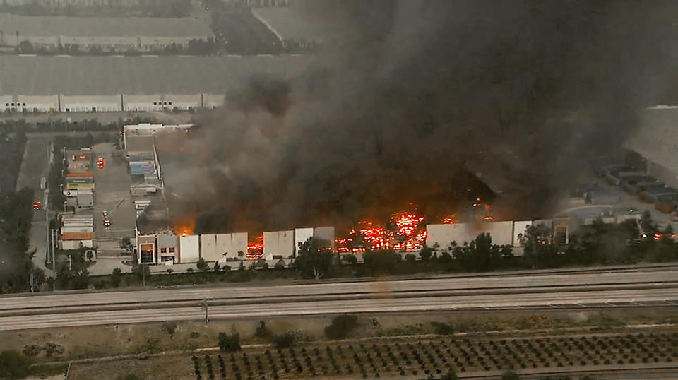 This photo taken from video provided by KABC-TV shows a raging fire destroying a huge commercial building Friday, June 5, 2020, in Redlands, Calif., about 60 miles (96 kilometers) east of Los Angeles. Firefighters from a half-dozen area agencies aided the Redlands Fire Department in shooting streams of water on flames that engulfed the structure, collapsed the roof and burned truck trailers parked at loading docks. The nearby 10 Freeway was shut down in both directions for several hours as flames shot high into the air. (KABC-TV via AP)