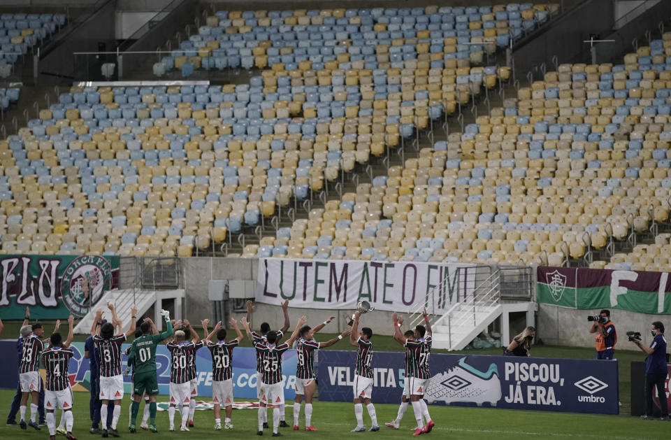 Players of Fluminense celebrate with their trophy after defeating Flamengo in a penalty shootout at the the Rio de Janeiro soccer league final match at the Maracana stadium in Rio de Janeiro, Brazil, Wednesday, July 8, 2020. The match was played without spectators to curb the spread of COVID-19. (AP Photo/Leo Correa)