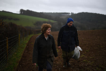 Helen and Andrew Arnold, walk through their brassica and sheep farm called Venton Veor in Liskeard Cornwall, Britain March 8, 2019. Andrew and Helen only recently told each other they voted on opposite sides in the referendum. She wanted to Leave, he voted Remain. "I don't like change," Andrew said. REUTERS/Clodagh Kilcoyne/Files