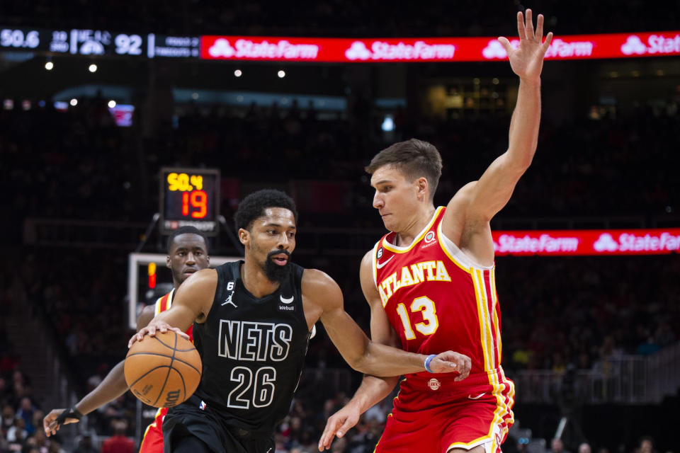 Brooklyn Nets guard Spencer Dinwiddie, left, drives against Atlanta Hawks guard Bogdan Bogdanovic during the second half of an NBA basketball game, Sunday, Feb. 26, 2023, in Atlanta. (AP Photo/Hakim Wright Sr.)