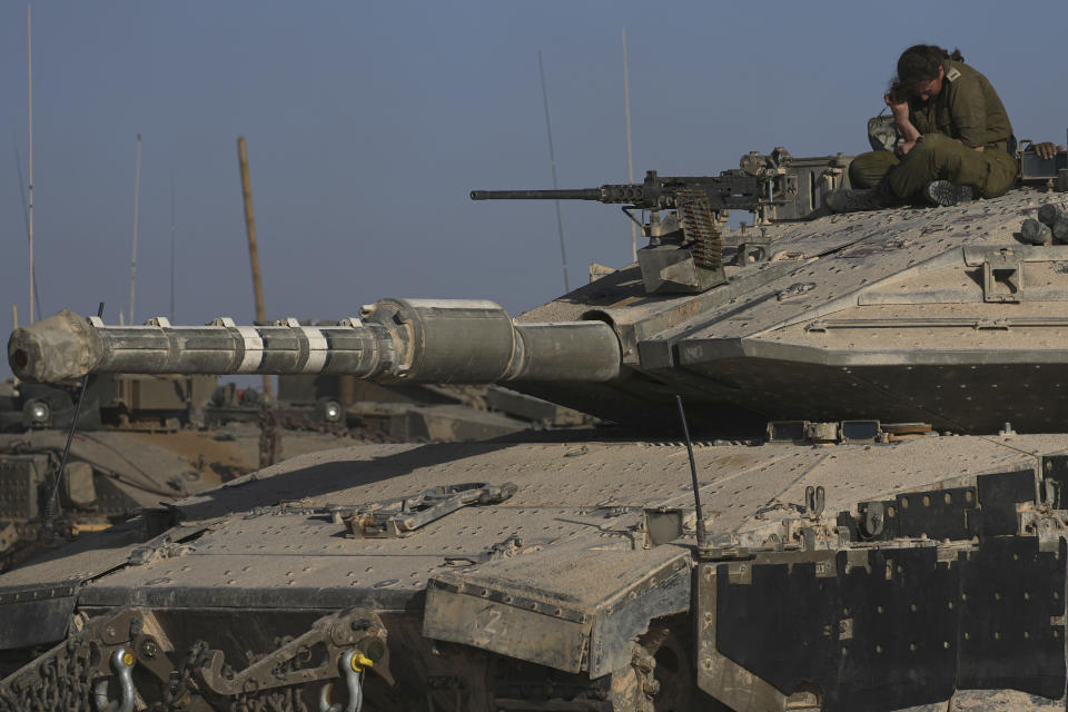 An Israeli female soldier sits atop a tank in a staging area near the Gaza border in southern Israel, Friday, May 24, 2024. (AP Photo/Tsafrir Abayov)