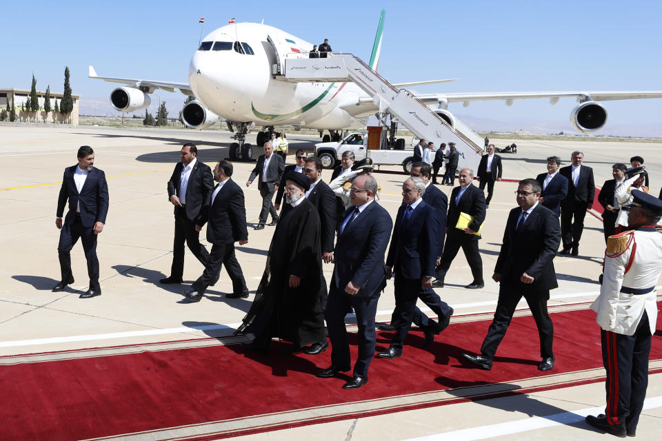 Iranian President Ebrahim Raisi, center left, walks on the red carpet with Syrian Economy Minister Samer al-Khalil upon his arrival to the airport in Damascus, Syria, Wednesday, May 3, 2023. It is the first visit by an Iranian head of state to war-torn Syria since the beginning of the country's uprising-turned-civil-war in 2011, in which Tehran helped tip the balance of power to the government. (AP Photo/Omar Sanadiki)