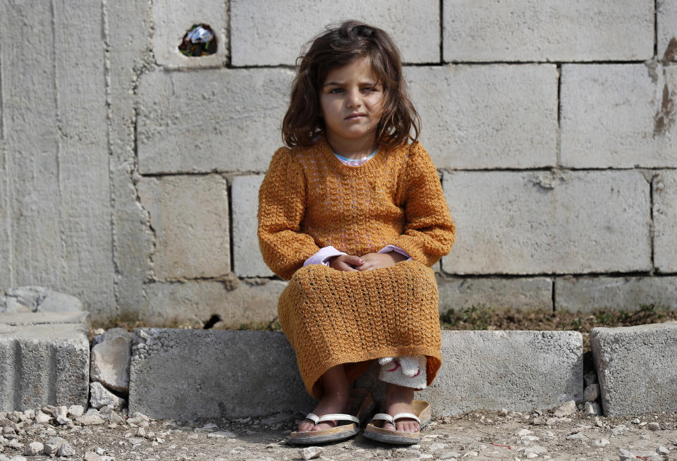 A displaced Syrian girl sits outside her family's tent at a refugee camp in Bar Elias, Bekaa Valley, Lebanon, Friday, March 5, 2021. UNICEF said Wednesday, March 10, 2021 that Syria’s 10-year-long civil war has killed or wounded about 12,000 children and left millions out of school in what could have repercussions for years to come in the country. The country's bitter conflict has killed nearly half a million people, wounded more than a million and displaced half the country’s population, including more than 5 million as refugees. (AP Photo/Hussein Malla)