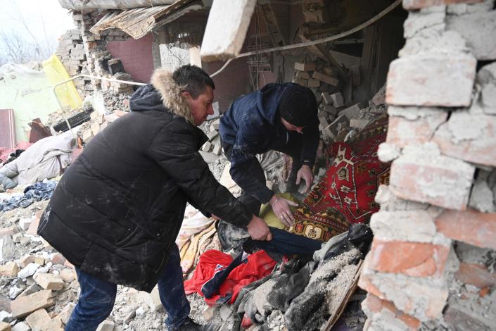 Ľudia prehľadávajú trosky domu po ruskom nálete v dedine Velika Velchanitsya neďaleko Ľvova 9. marca 2023.