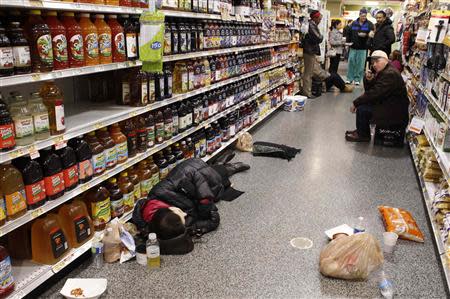 People rest at the aisle of a Publix grocery store after being stranded due to a snow storm in Atlanta, Georgia, January 29, 2014. REUTERS/Tami Chappell