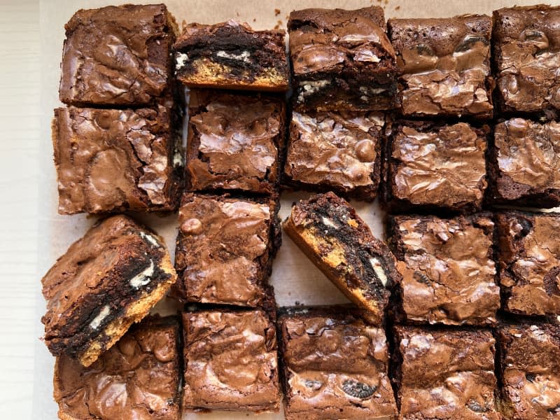 Slutty brownies cut on wax paper.