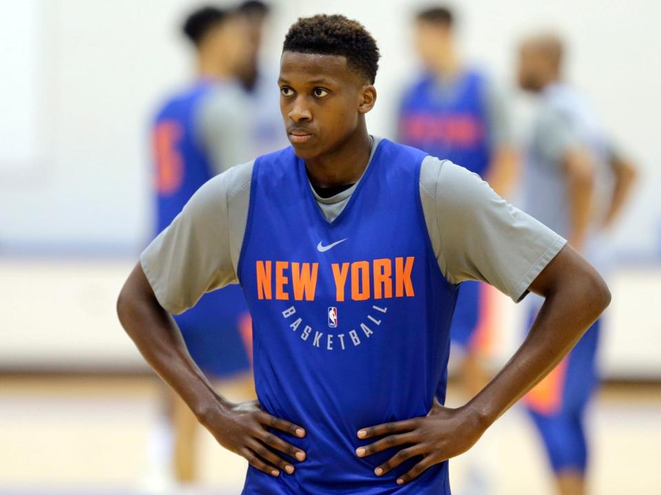 frank ntilikina with his hands on his hips wearing a New York basketball warmup jersey