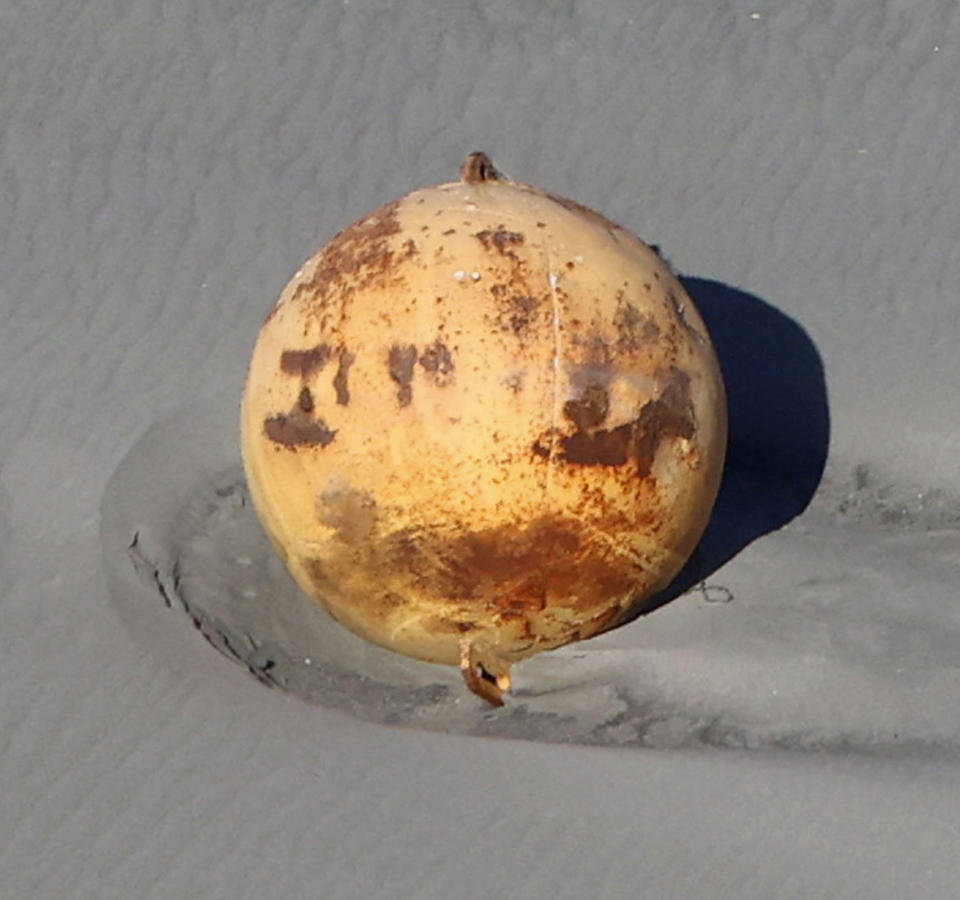 An aerial view taken Tuesday shows the large metallic object that washed ashore in Hamamatsu, Japan. (Kyodo via Reuters)