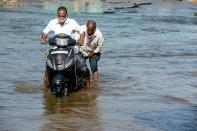 Motorists make their way on a flooded street following heavy rains in Hyderabad on October 16, 2020. (Photo by NOAH SEELAM / AFP) (Photo by NOAH SEELAM/AFP via Getty Images)