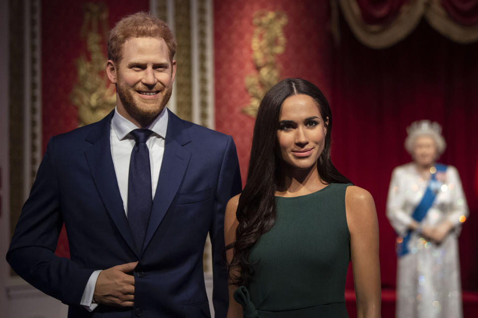 The figures of Britain's Prince Harry and Meghan, Duchess of Sussex, left, are moved from their original positions next to Queen Elizabeth II, Prince Philip and Prince William and Kate, Duchess of Cambridge, at Madame Tussauds in London, Thursday Jan. 9, 2020. Madame Tussauds moved its figures of Prince Harry and Meghan, Duchess of Sussex from its Royal Family set to elsewhere in the attraction. (Victoria Jones/PA via AP)