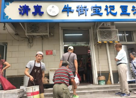 The Arabic script on the signboard of a halal restaurant is seen covered with Chinese characters reading "time-honored brand", at Niujie area in Beijing