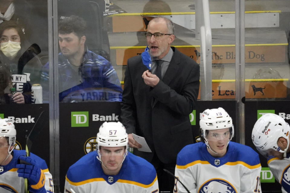 Buffalo Sabres head coach Don Granato removes his mask to yell to his team during the first period of an NHL hockey game against the Boston Bruins, Saturday, Jan. 1, 2022, in Boston. (AP Photo/Mary Schwalm)