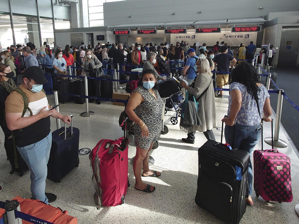 Airline passengers wait to check-in at George Bush Intercontinental Airport Sunday, May 16, 2021, in Houston. Airline travel is increasing as more Americans are getting the COVID-19 vaccination. (AP Photo/David J. Phillip)