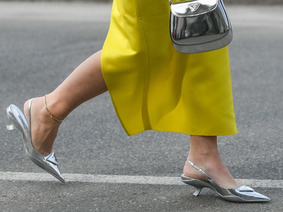 Metallic shoes paired with a metallic purse and yellow skirt.
