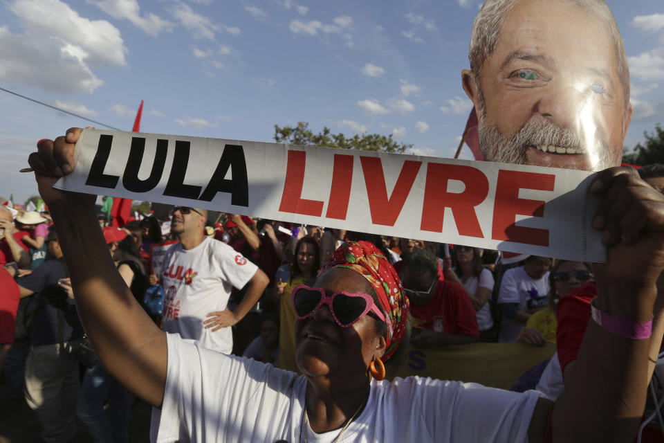 A supporter of jailed, former President Luiz Inacio Lula da Silva, holds a sign that reads in Portuguese: "Free Lula" at a march in Brasilia, Brazil, Wednesday, Aug. 15 2018. Supporters of jailed da Silva rallied outside the court where his party registered his candidacy for president. (AP Photo/Eraldo Peres)