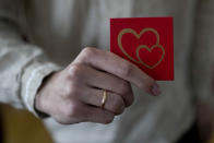 Yevhen Nalyvaiko holds the ring box after marrying Daria Ponomarenko in Kyiv, Ukraine, Wednesday, June 15, 2022. A growing number of couples in Ukraine are speedily turning love into matrimony because of the war with Russia. Some are soldiers, marrying just before they head off to fight. Others are united in determination that living and loving to the full are more important than ever in the face of death and destruction. (AP Photo/Natacha Pisarenko)