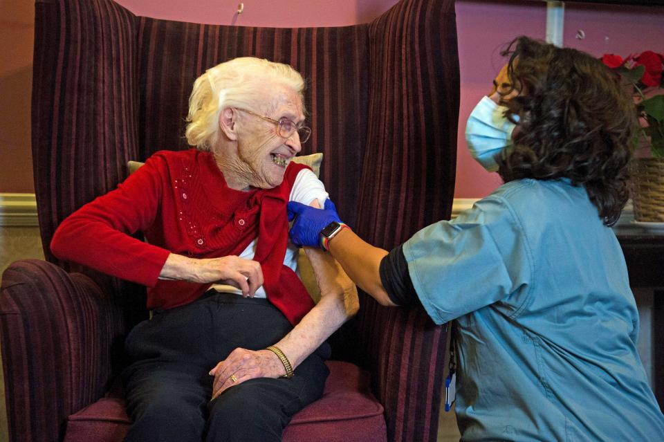 One hundred year-old Ellen Prosser, known as Nell,  receives the Oxford/AstraZeneca COVID-19 vaccine from Dr Nikki Kanani at the Sunrise Care Home in Sidcup, south east London on January 7, 2021. - A mass rollout by GP practices of the Oxford/AstraZeneca Covid-19 vaccine has begun, as hospitals across the United Kingdom face rising numbers of seriously ill patients. (Photo by Kirsty O'Connor / POOL / AFP) (Photo by KIRSTY O'CONNOR/POOL/AFP via Getty Images)