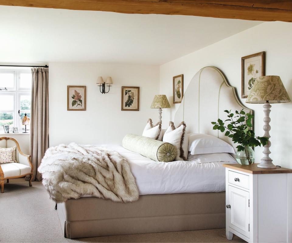 White bedside table, fur blanket, armchair