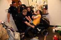 <p>JUN. 29, 2017 – Dawn Russell gets arrested by Denver police officers after refusing the vacate the offices of Senator Cory Gardner in Denver, Colorado. A handful of people, all of whom are with ADAPT, held a sit-in for 58 hours in the tiny front lobby space in the office of Colorado Senator Cory Gardner. They are asking the senator to vote against the new health care bill. As they were arrested protesters chanted “I would rather go to jail than die without Medicaid.” ADAPT is a national grass-roots community that organizes disability rights activists to engage in nonviolent direct action, including civil disobedience, to assure the civil and human rights of people with disabilities to live in freedom. (Photo: Helen H. Richardson/The Denver Post via Getty Images) </p>