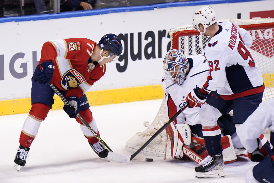 Florida Panthers center Frank Vatrano (77) attempts a shot at Washington Capitals goaltender Ilya Samsonov and center Evgeny Kuznetsov (92) during the first period of an NHL hockey game, Tuesday, Nov. 30, 2021, in Sunrise, Fla. (AP Photo/Wilfredo Lee)