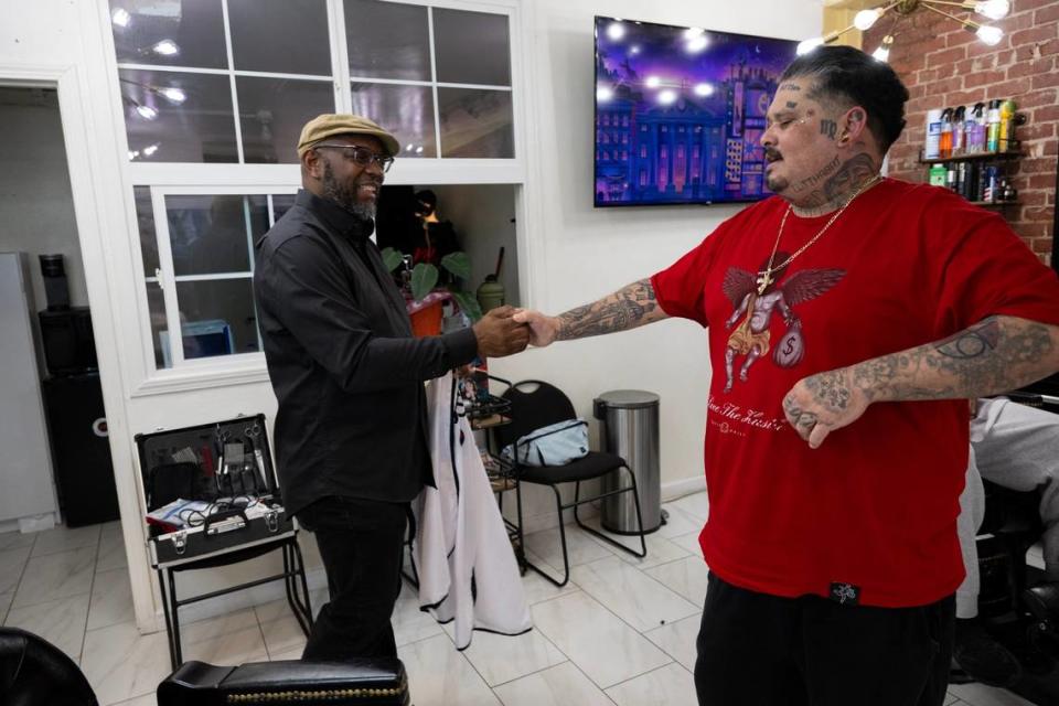 Marichal Brown finishes fist bumps customer Joe Chavarria after his haircut at HAIRitage Salon on Thursday, Feb. 29, 2024, in Sacramento. Brothers Marichal and Rodney Brown are owners of HAIRitage Salon and their shop are also part of a growing national network of Black barbers and stylists who have become frontline mental health advocates in their communities as part of the Confess Project. The project trains and helps Black haircare and other workers to help be mental health advocates for Black men, boys and their families. Paul Kitagaki Jr./pkitagaki@sacbee.com