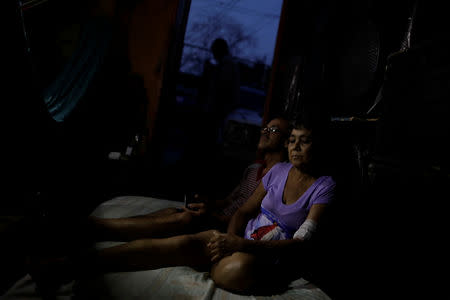 FILE PHOTO: Maria Esis, 52, a kidney disease patient, sits next to her husband Lino Lopez, as they wait for the electricity to return during a blackout, at their house in Maracaibo, Venezuela April 11, 2019. REUTERS/Ueslei Marcelino