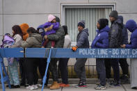 Migrants stand in line to receive food from the nonprofit Chi-Care Thursday, Jan. 11, 2024, in Chicago. In the city of Chicago's latest attempt to provide shelter to incoming migrants, several CTA buses were parked in the area of 800 South Desplaines Street to house people in cold winter weather. (AP Photo/Erin Hooley)