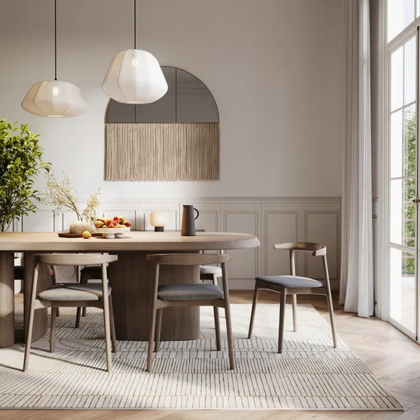 A modern dining room with a table set for two and various chairs around, adjacent to a bright window