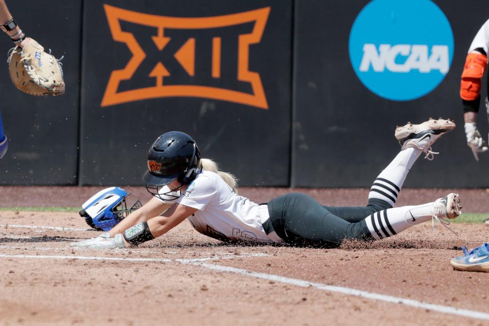 Oklahoma State infielder Rosie Davis (26) scores a run in the first inning of a softball game between the Oklahoma State Cowgirls and Kentucky in the Stillwater Regional of the NCAA Tournament, Saturday, May 18, 2024. Oklahoma State won 6-2.