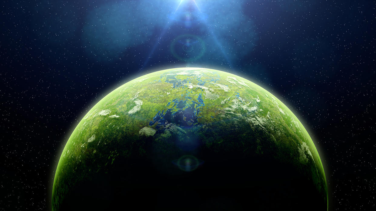  An illustration of a green and blue planet in space with light shining on it. . 