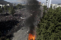 Anti-government protesters take part in a ongoing demonstrations triggered by an increase in subway fares in Santiago, Chile, Monday, Oct. 21, 2019. Protesters defied an emergency decree and confronted police in Chile's capital on Monday, continuing disturbances that have left at least 11 dead. (AP Photo/Esteban Felix)