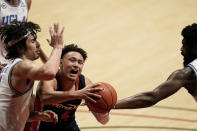 Pepperdine guard Colbey Ross drives to the basket as UCLA guard Jaime Jaquez Jr., left, and forward Cody Riley, right, defend during the second half of an NCAA college basketball game Friday, Nov. 27, 2020, in San Diego. (AP Photo/Gregory Bull)