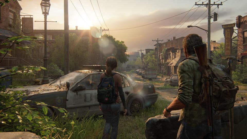 Pantalla de The Last of Us Parte I. Joel y Ellie caminan entre autos abandonados en un pequeño pueblo abandonado.