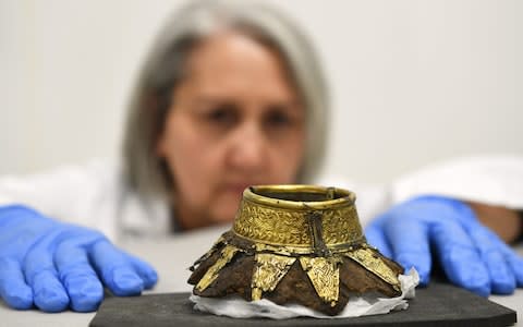 The remains of a wooden drinking vessel decorated with a gold neck - Credit: PA