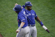 Toronto Blue Jays' Danny Jansen, left, is congratulated by Marcus Semien after hitting a two-run home run against the Baltimore Orioles during the fourth inning of the first game of a baseball doubleheader, Saturday, Sept. 11, 2021, in Baltimore. (AP Photo/Julio Cortez)