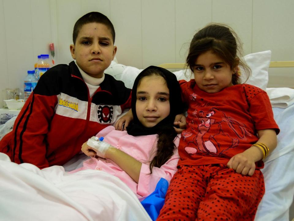 Amina (centre) with her brother and sister after the operation (Simona Sikimic/Save the Children)