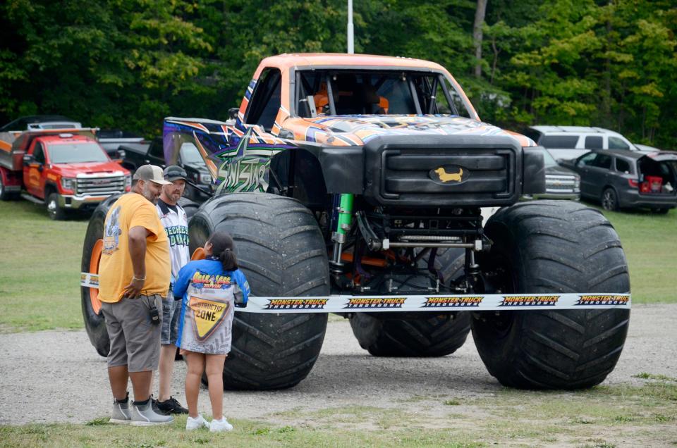 People admire some of the monster trucks that will be featured at the 2023 Emmet-Charlevoix County Fair.