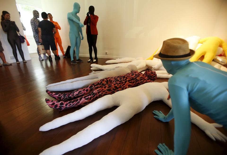 Participants wearing Zentai costumes, or skin-tight bodysuits from head to toe, mingle before their march down the shopping district of Orchard Road during Zentai Art Festival in Singapore May 23, 2015. Close to 50 participants strutted down the busy shopping district during the Zentai art festival which is jointly organized by the Japanese embassy. The festival includes performances and discussions on Zentai from May 22 to from June 5. REUTERS/Edgar Su