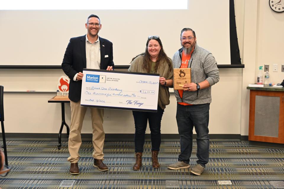 Mike Augenstein with Marion Technical College presents Crystal and Justin Bessler a $1,500 check and a plaque for coming in second in the Alluvial Private Wealth Forge Competition.