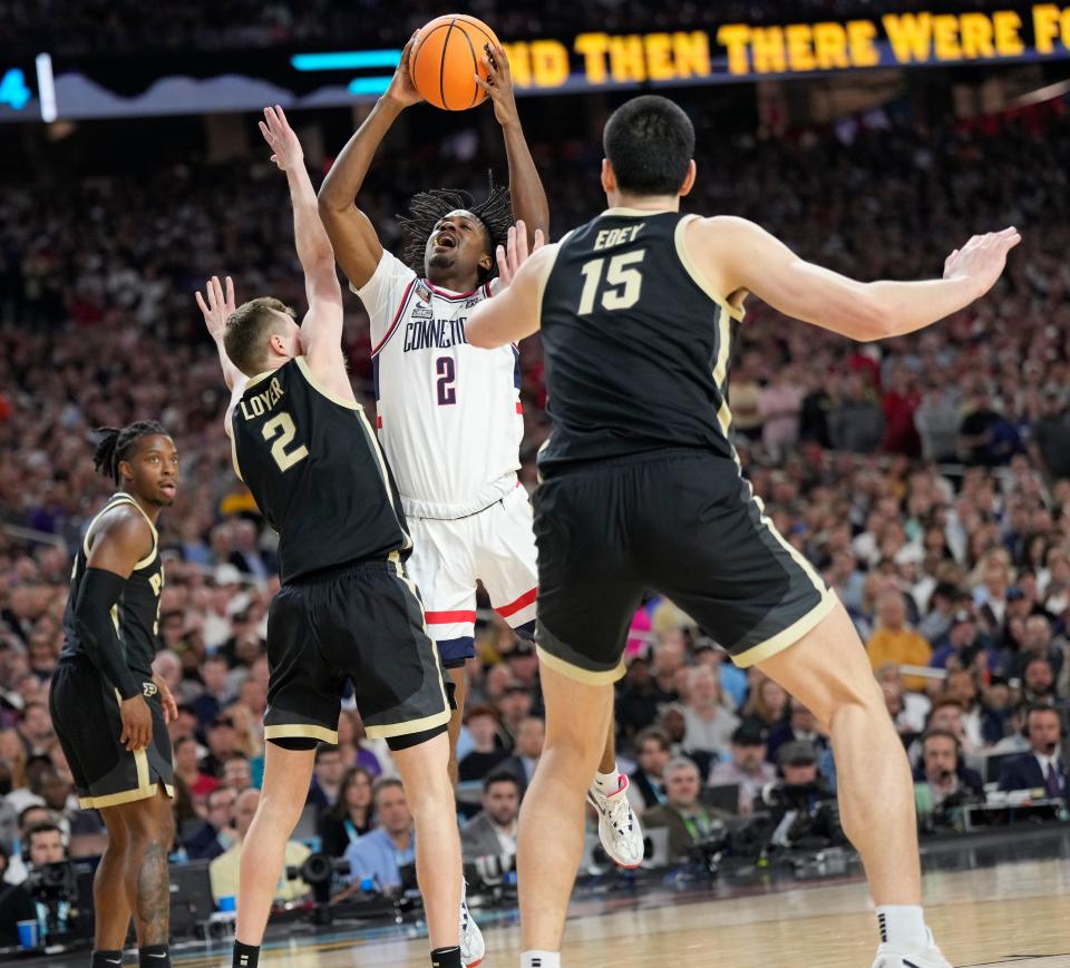 Connecticut Huskies guard Tristen Newton goes up for a shot against Purdue guard Fletcher Loyer (2) and center Zach Edey (15) during the championship game of the 2024 NCAA men's tournament at State Farm Stadium in Glendale on April 8, 2024.