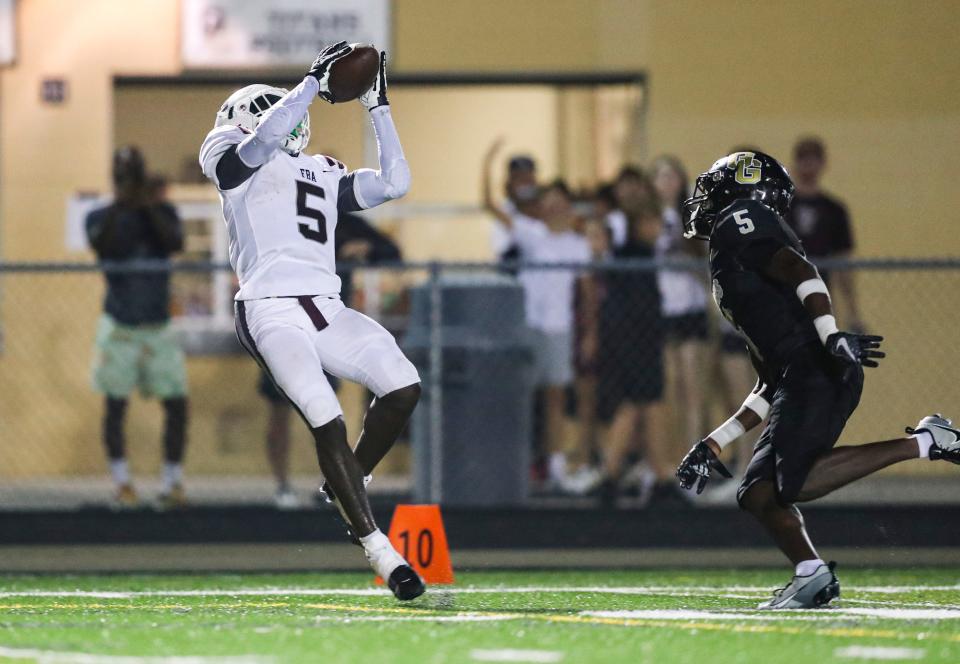 First Baptist Academy Lions receiver Winston Watkins Jr. (5) makes a catch while being guarded by Golden Gate Titans defensive back Jermaine Fabien (5) during the second quarter of a game at Golden Gate High School in Naples on Friday, Sept. 29, 2023.