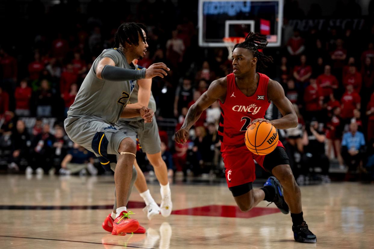 Cincinnati Bearcats guard Jizzle James (2) drives on West Virginia Mountaineers guard RaeQuan Battle (21). UC won by 36 Saturday to end their season, but they'll have to play WVU again in the Big 12 tournament Tuesday.