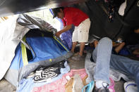 Jose Rodriguez, of Honduras closes is tent at a makeshift camp for migrants near the U.S.-Mexico border Friday, May 14, 2021, in Reynosa, Mexico. ing the heart-wrenching decision to separate from their children and send them into the U.S. alone. Many families with kids older than six have been quickly expelled from the country under federal pandemic-related powers that don't allow migrants to seek asylum. (AP Photo/Gregory Bull)