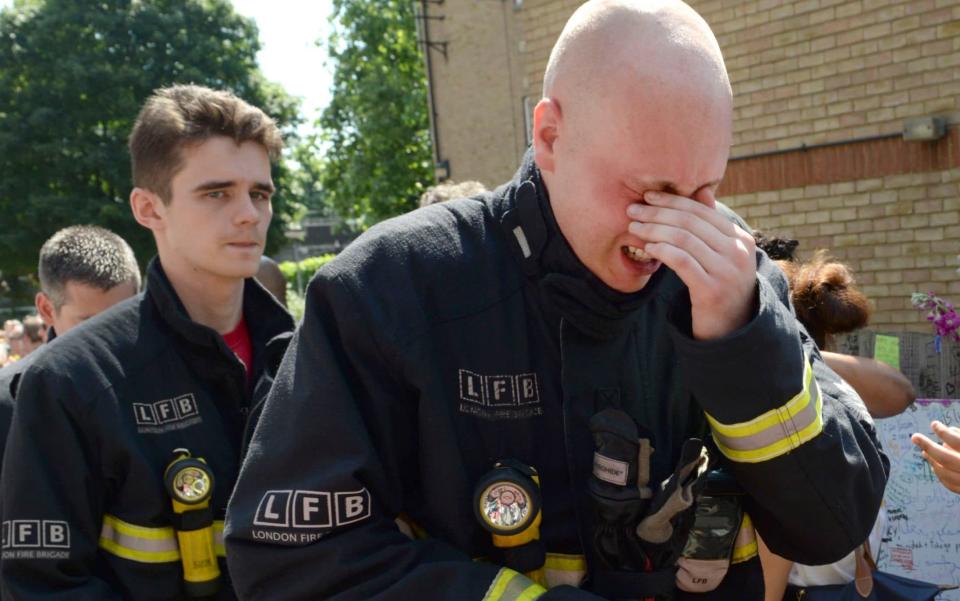 Kensington firefighters attend a minute's silence at the site of the Grenfell Tower blaze - © Eddie Mulholland