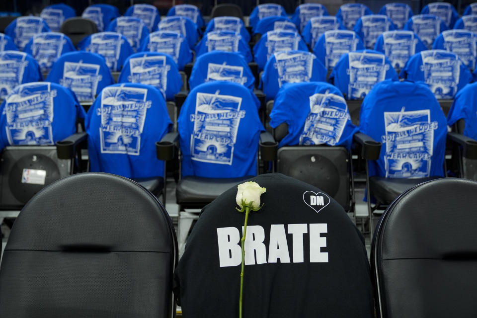 A rose and a t-shirt with the "DM" logo adorn the seat of former Golden State Warriors assistant coach Dejan Milojevic, who died Jan. 17 after suffering a heart attack, before an NBA basketball game between the Warriors and the Atlanta Hawks, Wednesday, Jan. 24, 2024, in San Francisco. (AP Photo/Godofredo A. Vásquez)