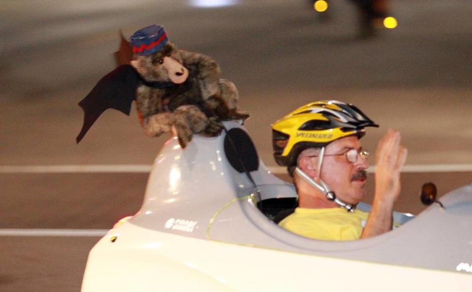 This unidentified bicyclist cruises with a flying monkey looking over his shoulder.