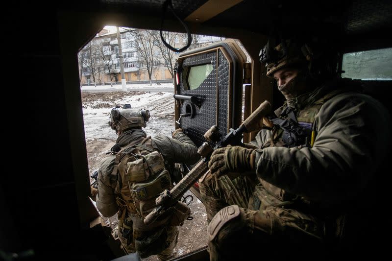 Ukrainian servicemen exit an armoured personnel carrier in the frontline town of Bakhmut